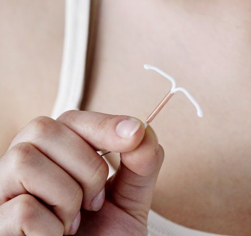 Hand holding copper IUD Hand holding copper IUD
